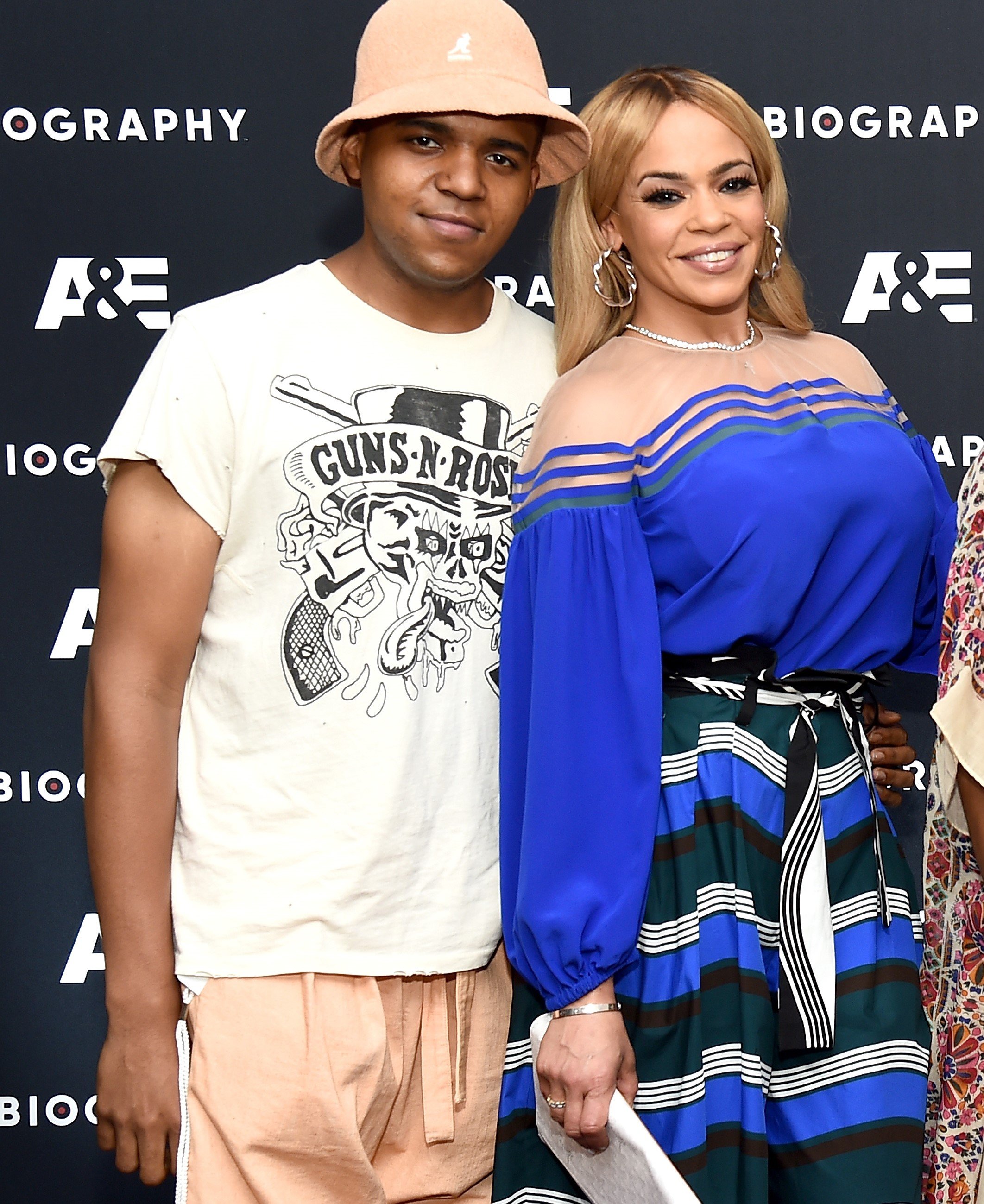 C.J. Wallace and his mother Faith Evans smile on the red carpet at the premiere The Life Of Notorious B.I.G biography.
