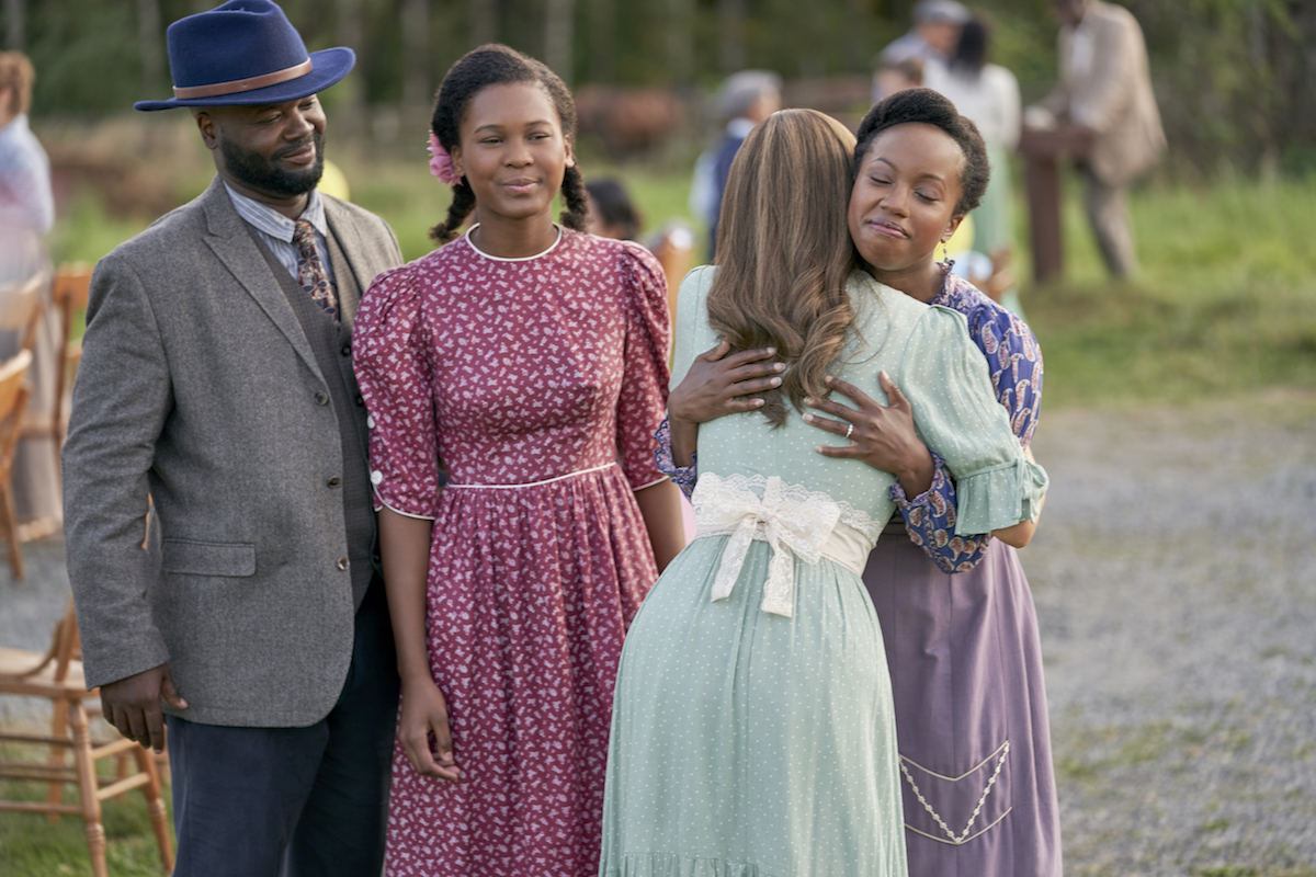 Elizabeth hugs Minnie while Angela and Joseph look on in an episode of When Calls the Heart