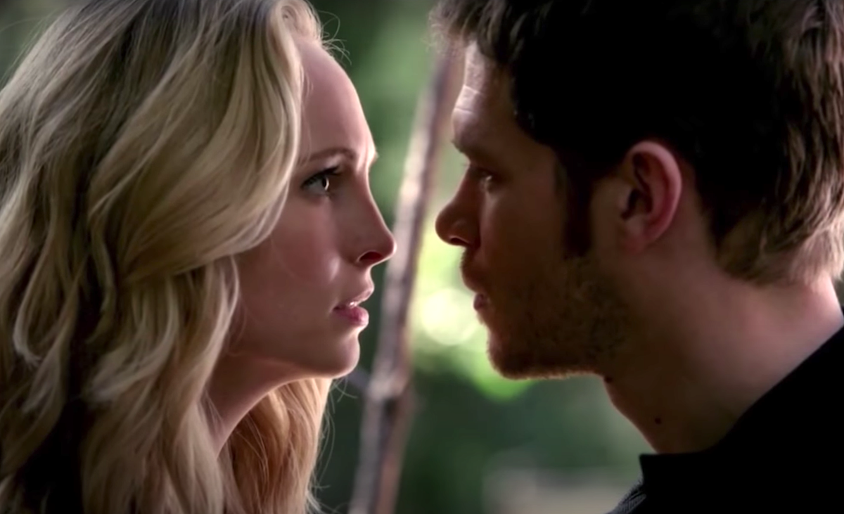 Candice King and Joseph Morgan stand face-to-face in the woods as Caroline and Klaus in 'The Vampire Diaries'