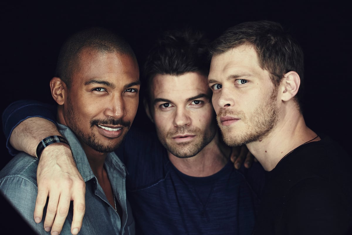 Charles Michael Davis, Daniel Gillies, and Joseph Morgan of 'The Originals' stand in front of a black background