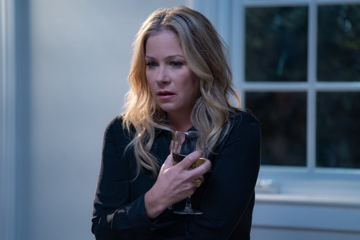 Christina Applegate holds a glass of wine and looks concerned in 'Dead to Me' on Netflix