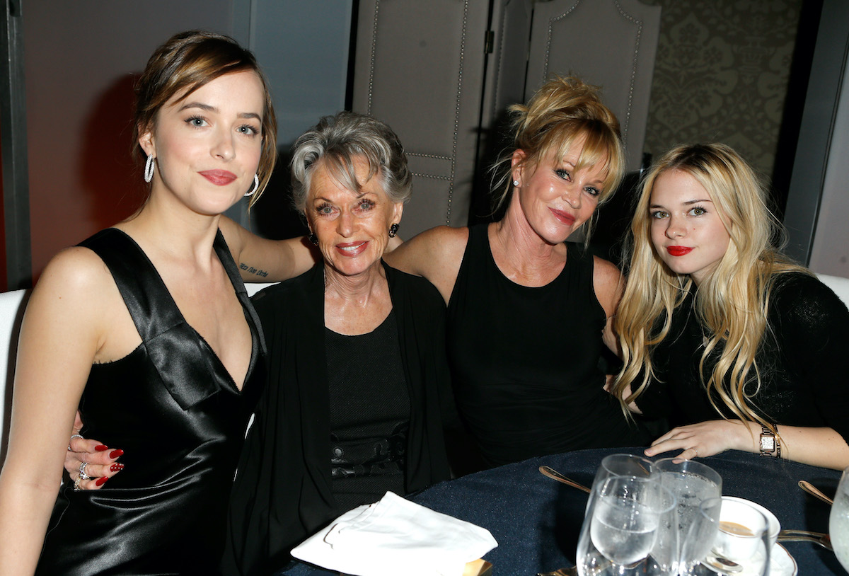 Dakota Johnson, Tippi Hedren, Melanie Griffith, and Stella Banderas sit at a table and pose for a photo at the 22nd Annual ELLE Women in Hollywood Awards on October 19, 2015