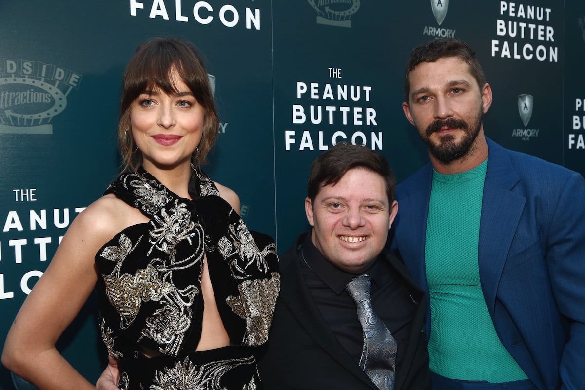 Dakota Johnson, Zack Gottsagen, and Shia LaBeouf pose for cameras together at a screening of 'The Peanut Butter Falcon'