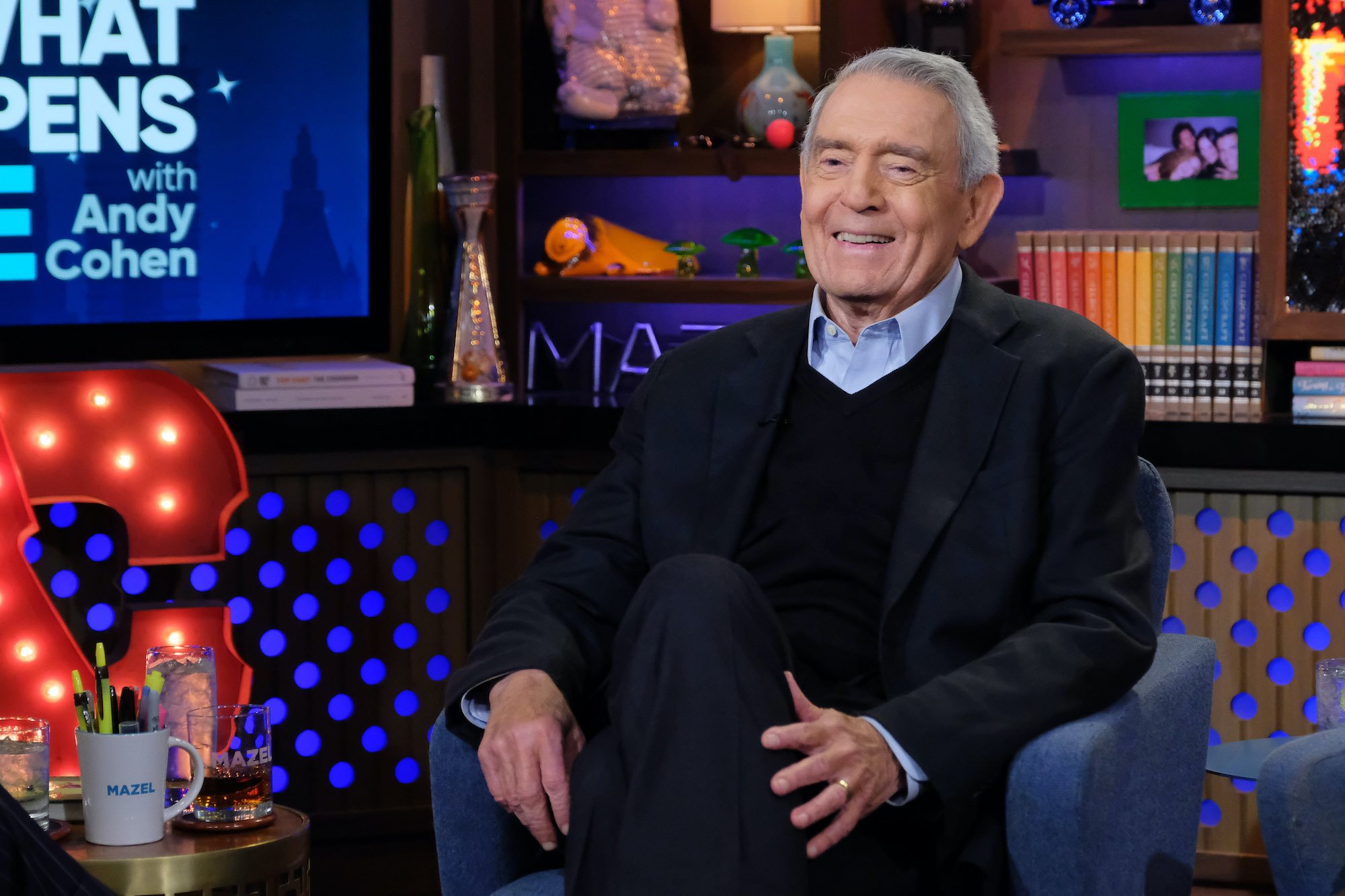 Dan Rather smiling, seated in an armchair
