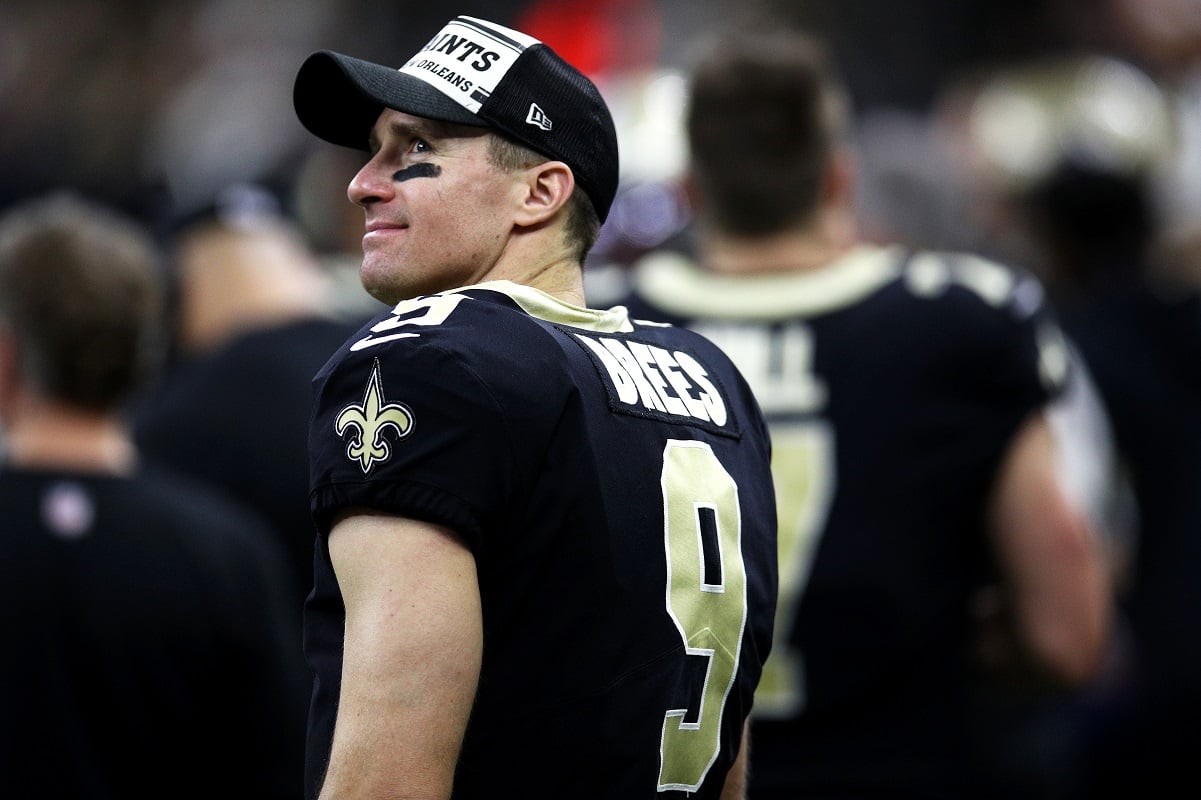 Drew Brees smiling while standing on the sidelines 