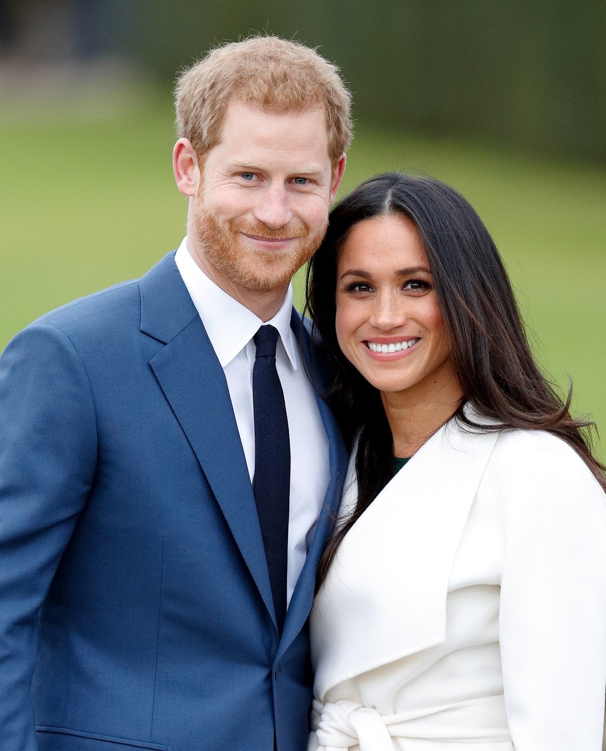 Prince Harry and Meghan Markle smiling at an official photocall to announce their engagement at The Sunken Gardens, Kensington Palace on November 27, 2017 in London, England