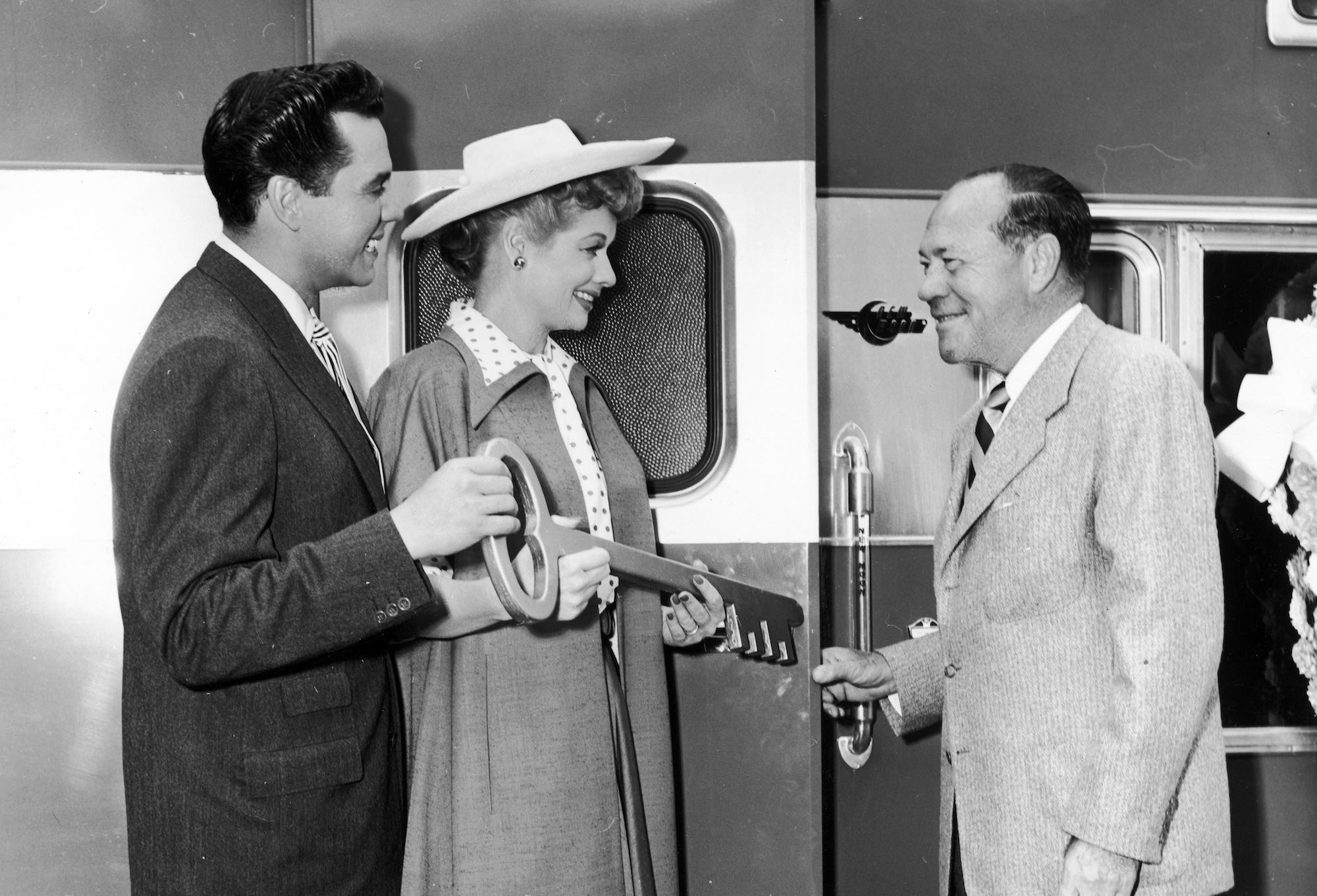 (L-R) Lucille Ball, Desi Arnaz, Eddie Mannix exchanging an award