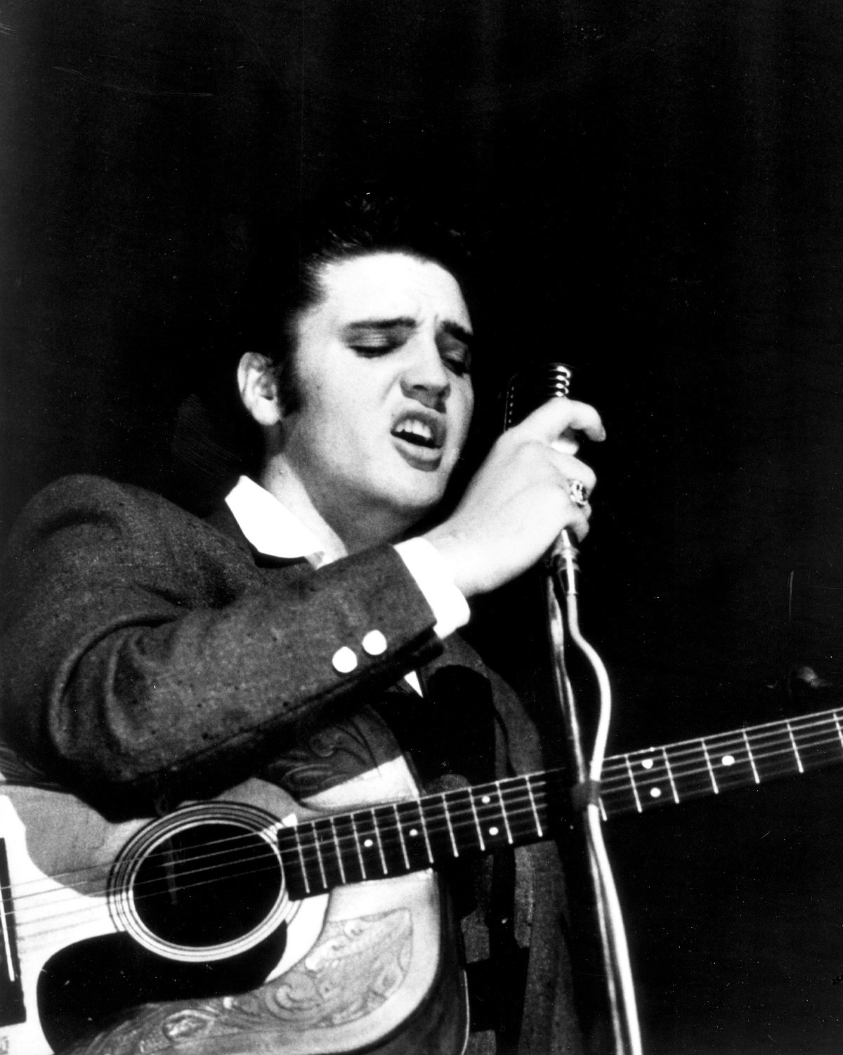 Elvis Presley performing with his acoustic guitar in 1955