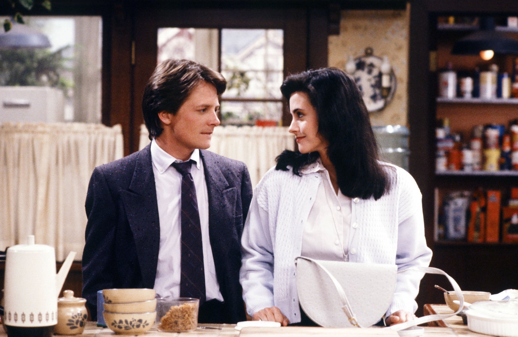 (L-R) Michael J. Fox as Alex P. Keaton, Courteney Cox as Lauren Miller on 'Family Ties' in a kitchen