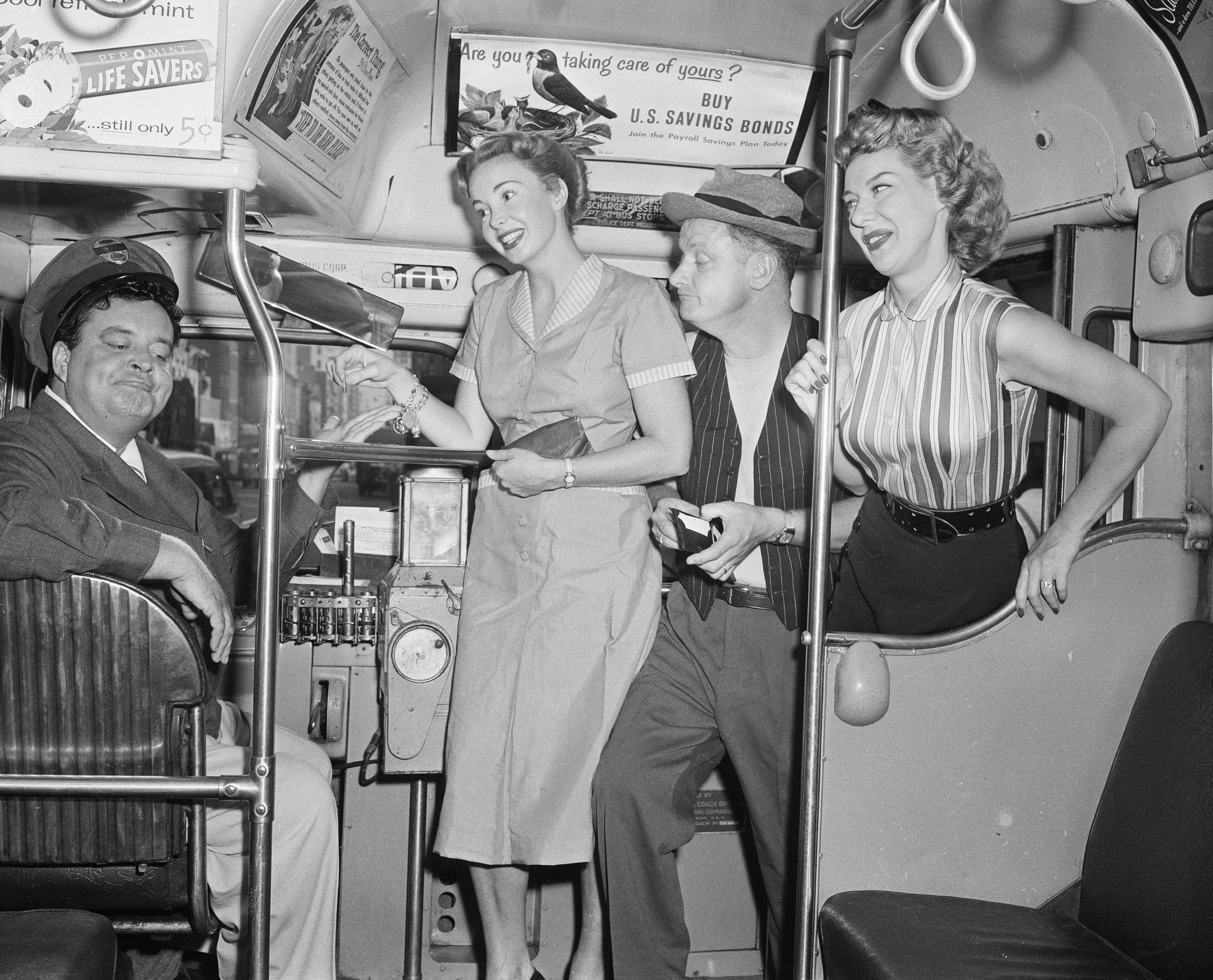 The cast of 'The Honeymooners' aboard a bus in 1955: Jackie Gleason as Ralph Kramden is in the driver's seat, while Audrey Meadows as Alice Kramden, Art Carney as Ed Norton and Joyce Randolph as Trixie Norton climb aboard
