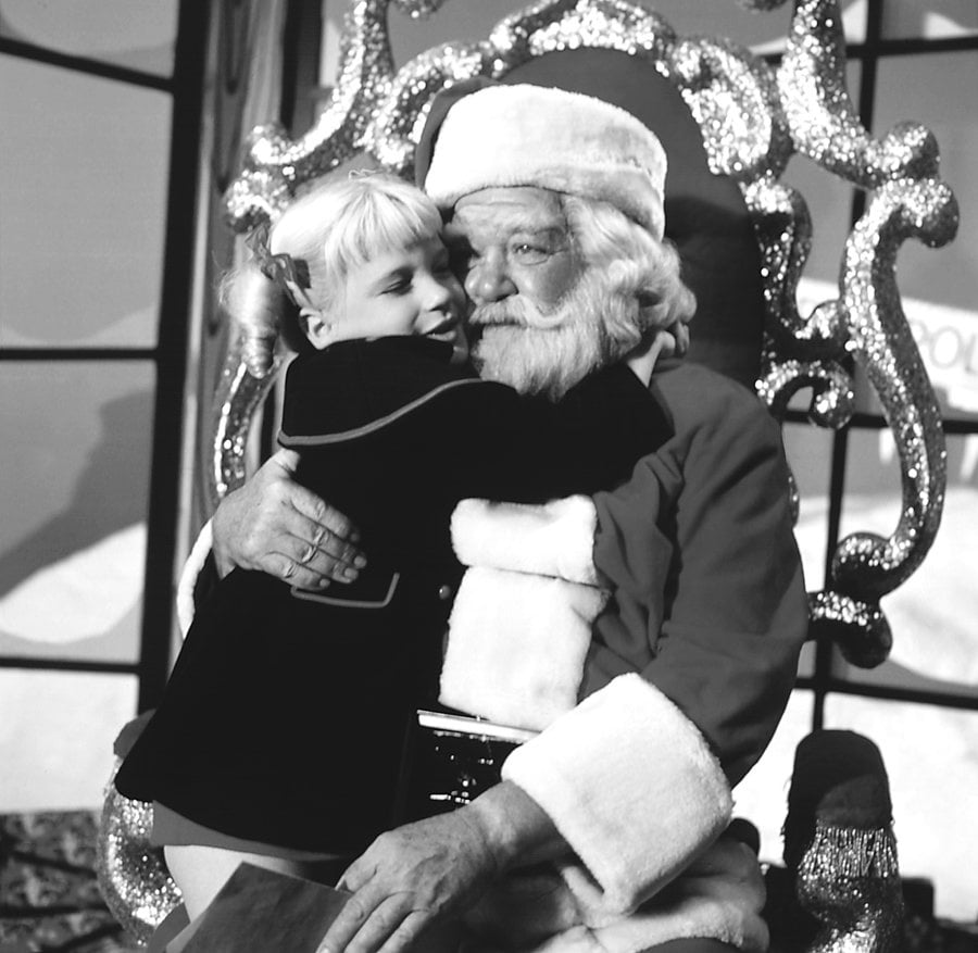 Susan Olsen as Cindy Brady sits on the lap of Hal Smith as Santa Claus in an episode of 'The Brady Bunch,' 1969