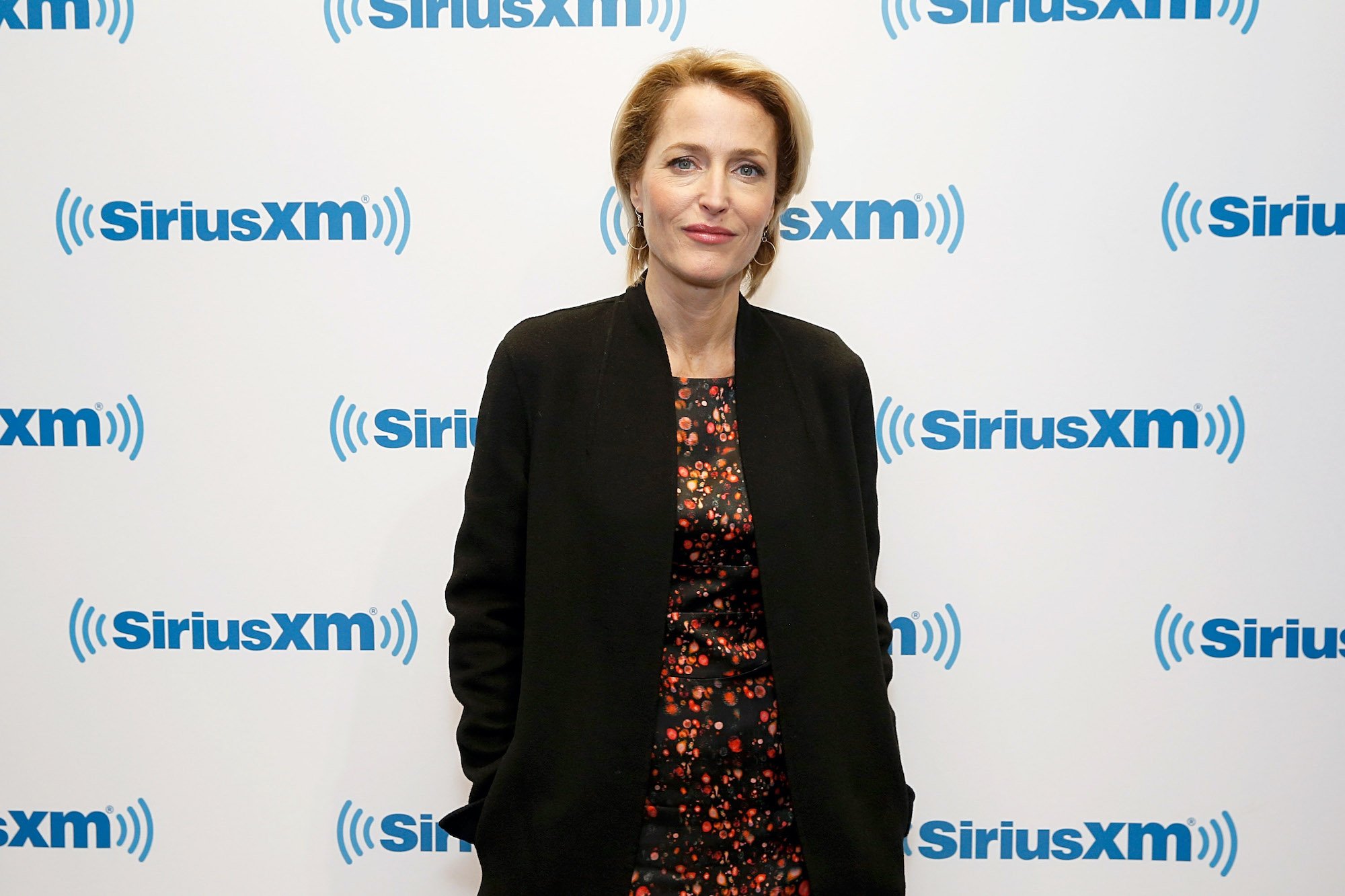 Gillian Anderson smiling in front of a white background