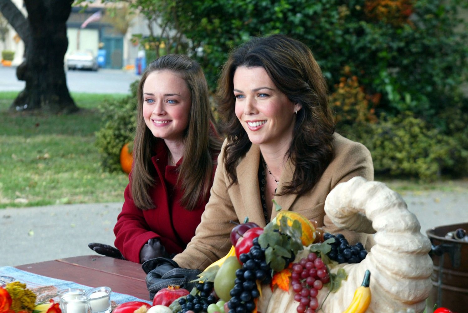 Rory Gilmore and Lorelai Gilmore sit at a table in the town square during season 3 of 'Gilmore Girls' 