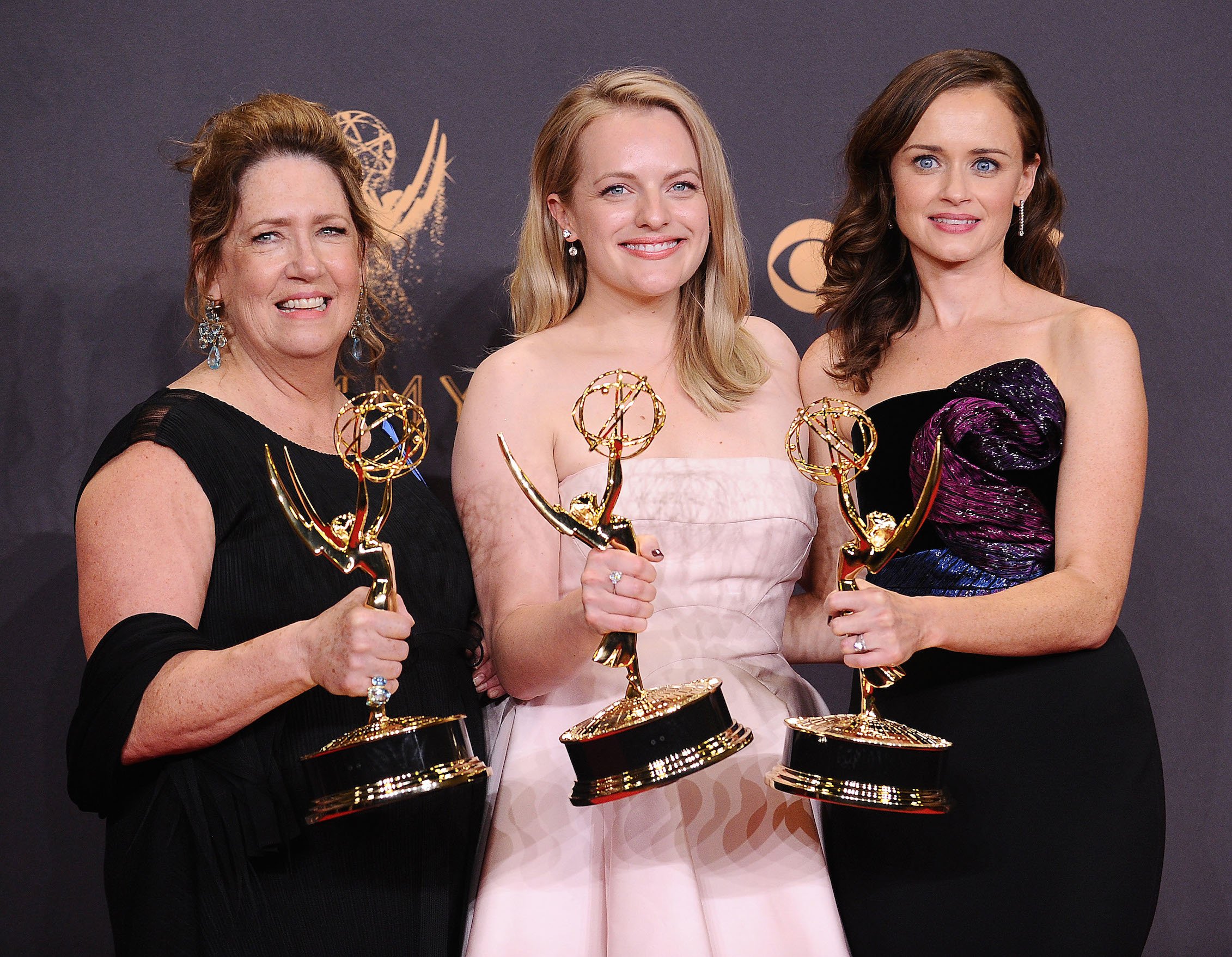 'The Handmaid's Tale' cast -- Ann Dowd, Elisabeth Moss, and Alexis Bledel, holding their awards and smiling after winning Outstanding Drama Series 