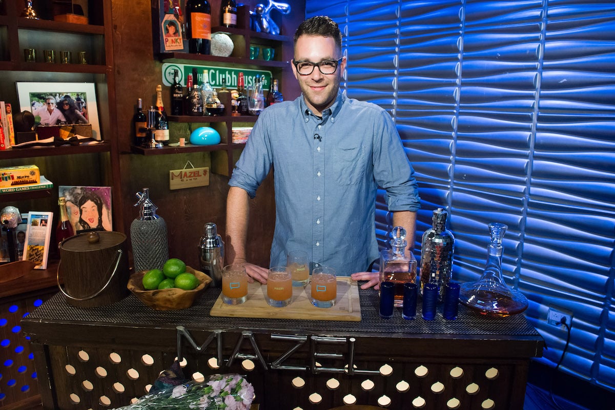 Ilan Hall standing behind a bar wearing blue