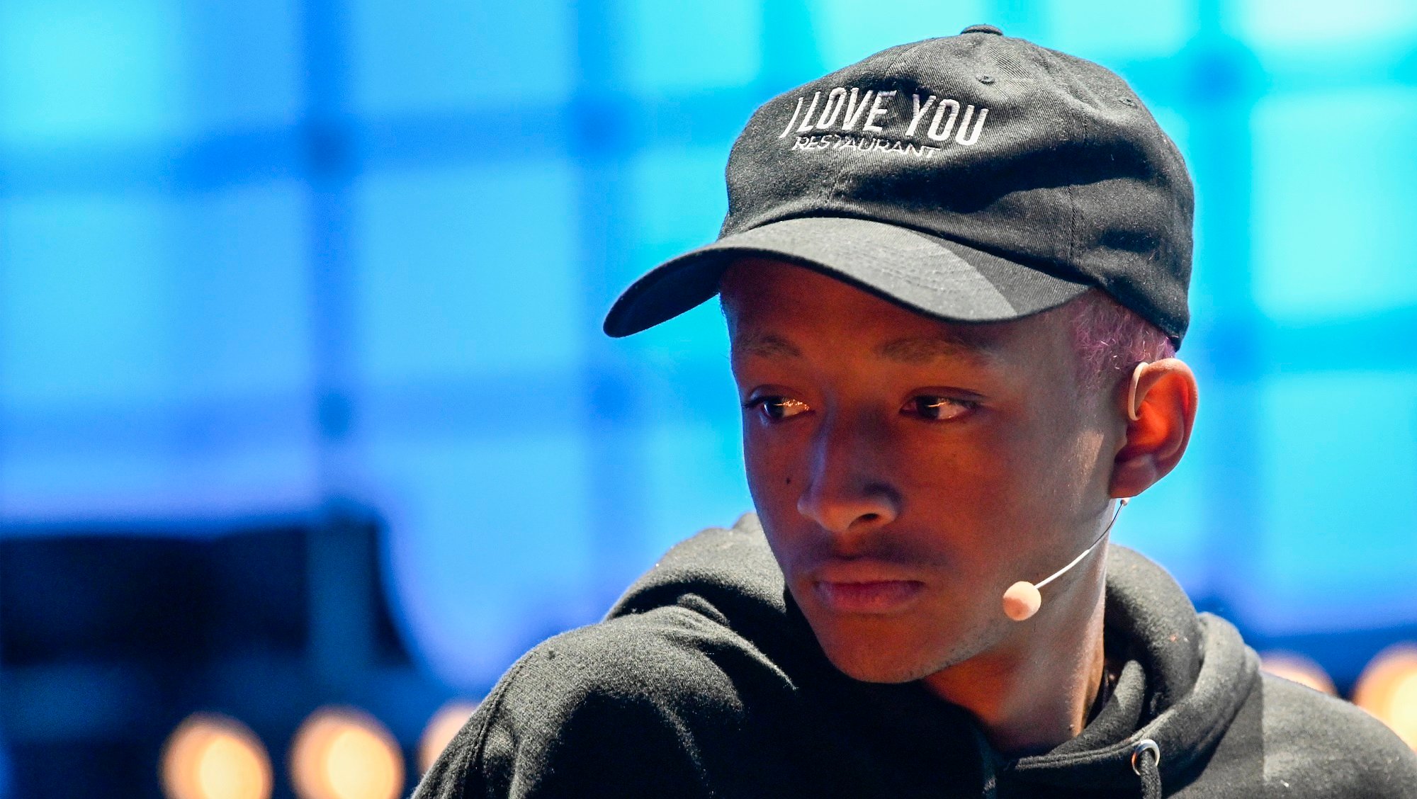 Jaden Smith wearing a baseball cap and headset mic