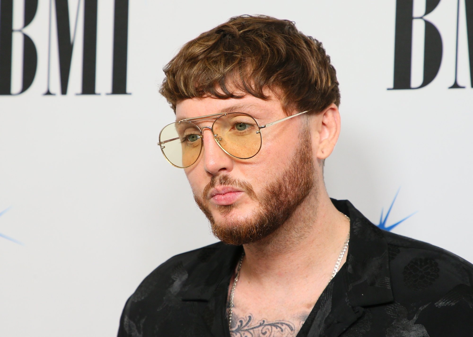 James Arthur smiling in front of a white background