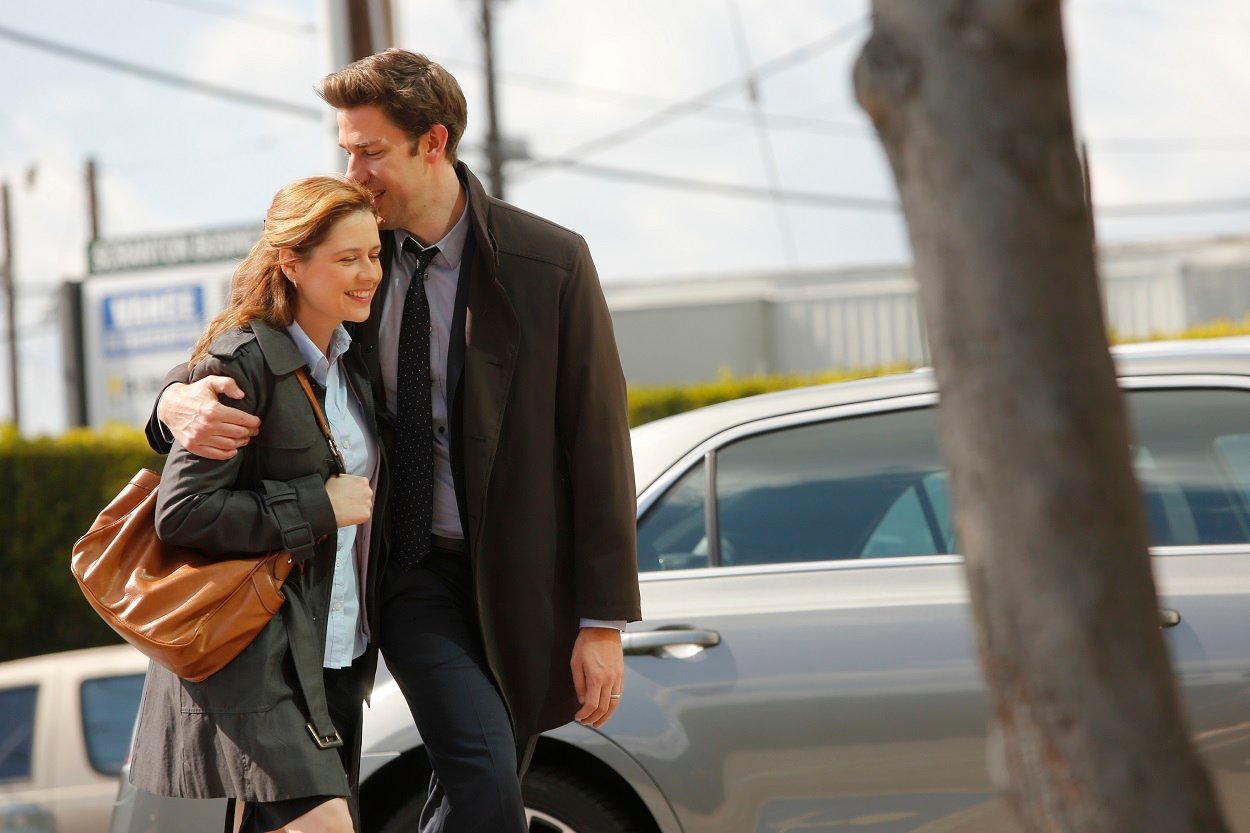 The Office stars Jenna Fischer and John Krasinski embracing while portraying Jim and Pam.