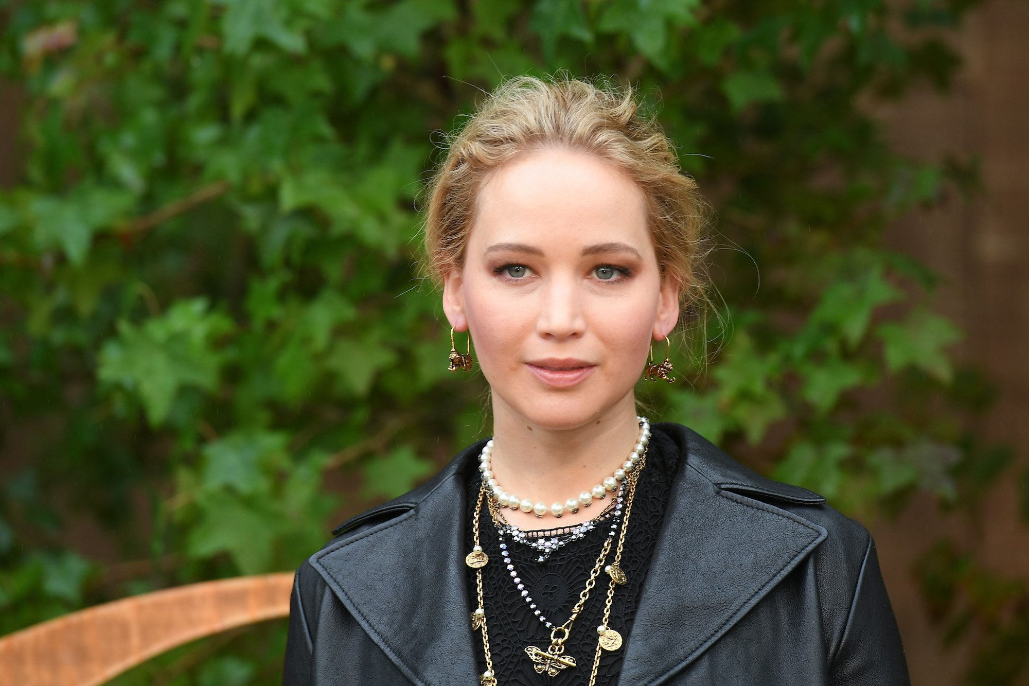 Jennifer Lawrence smiling in front of a green background