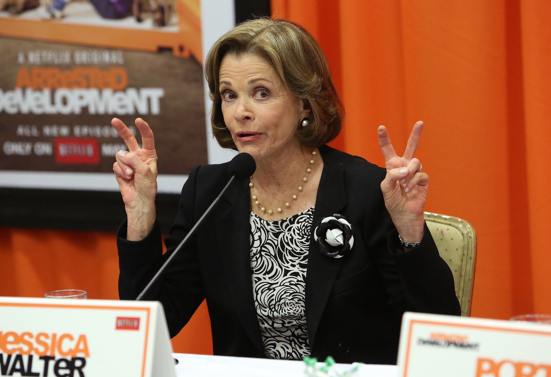 Jessica Walter from 'Arrested Development' speaking at a press conference with both hands up making air quotes