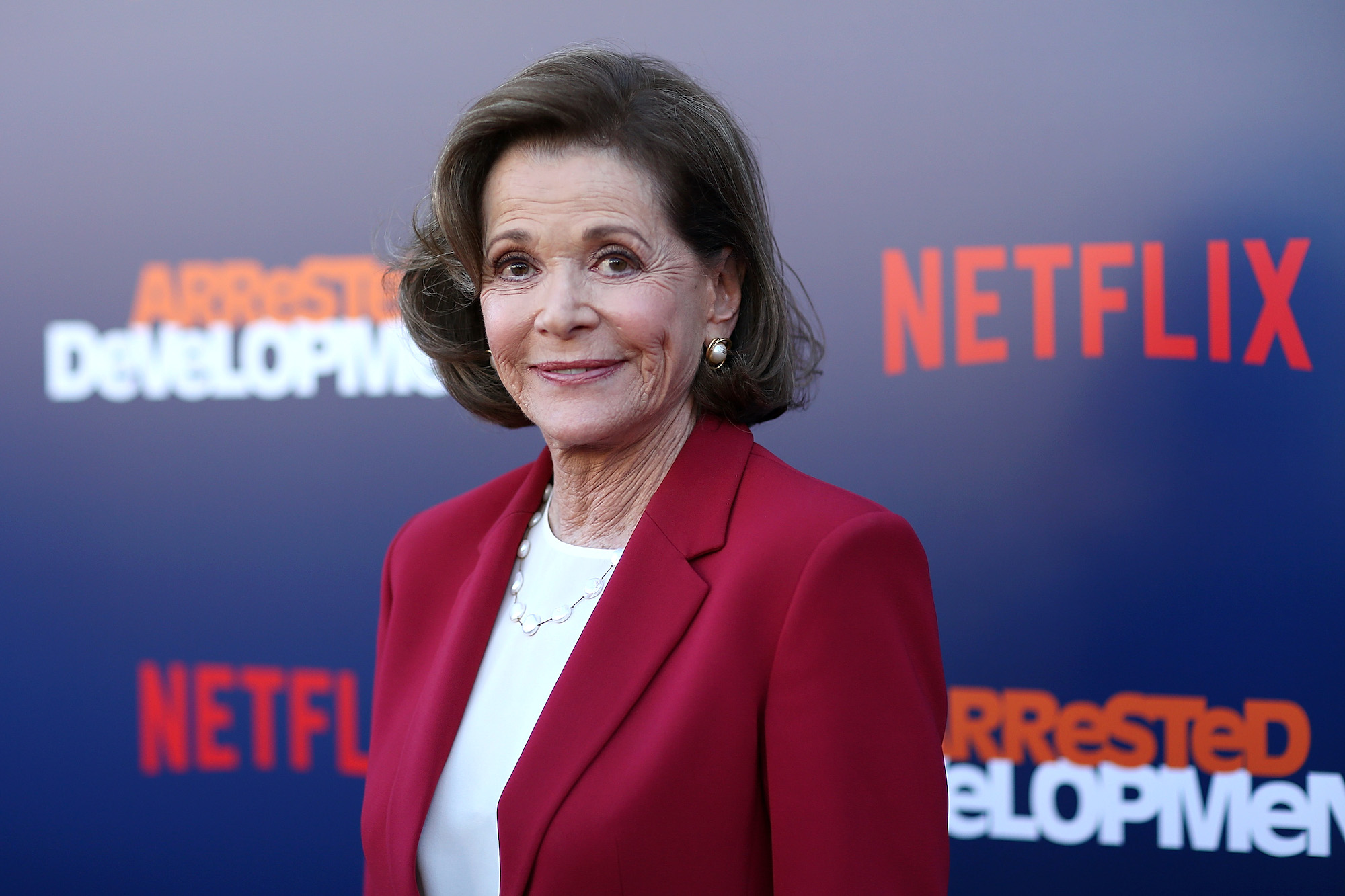 Jessica Walter smiling in front of a blue background