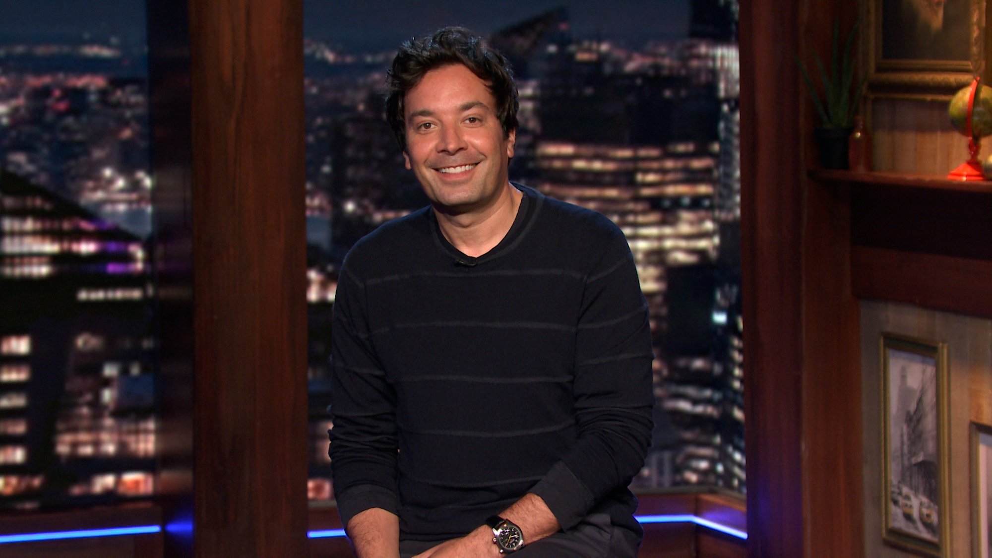 Jimmy Fallon smiling in front of a window