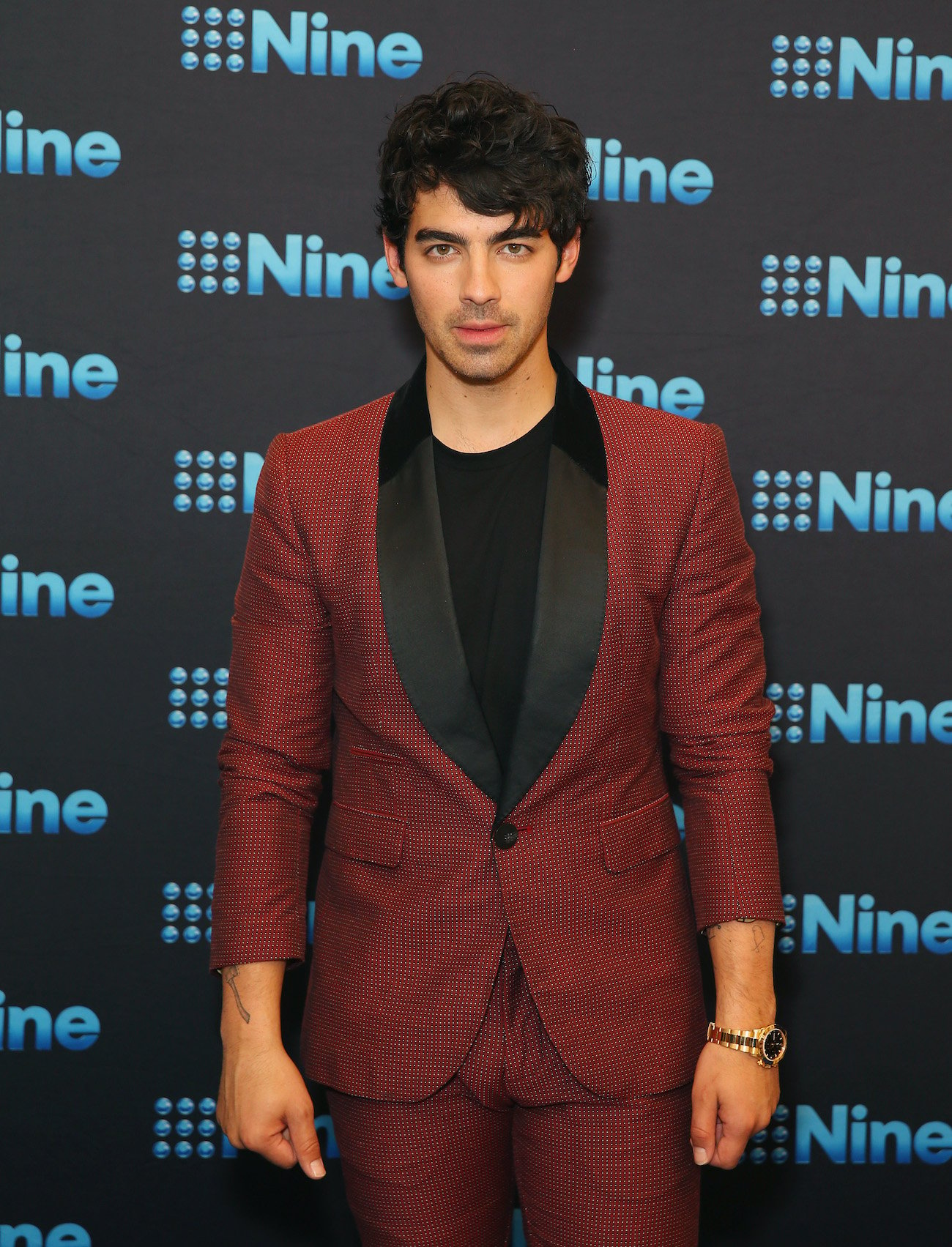Joe Jonas attends the Nine All Stars Event in a red suit