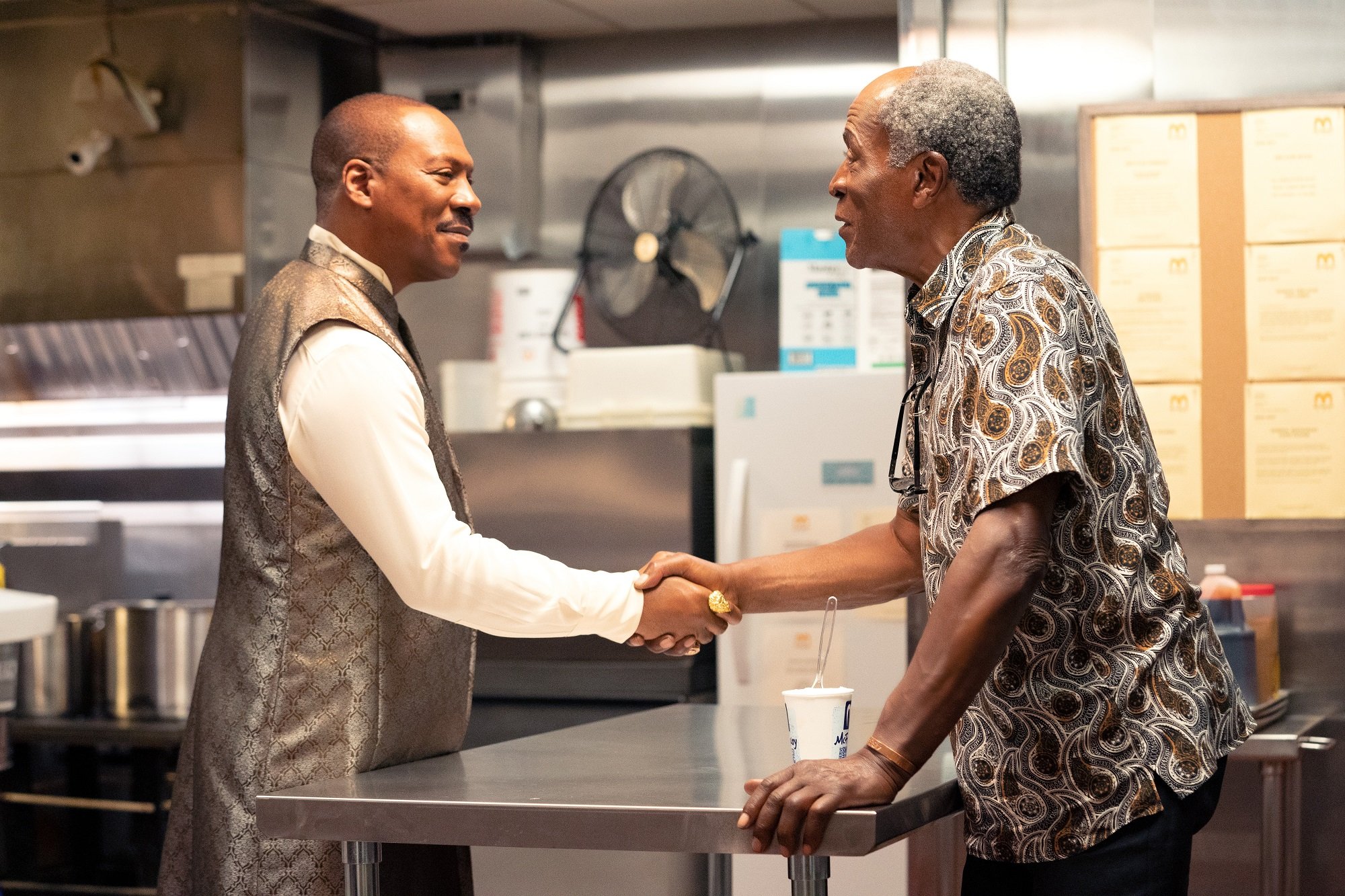 John Amos and Eddie Murphy shake hands on the McDowell's set