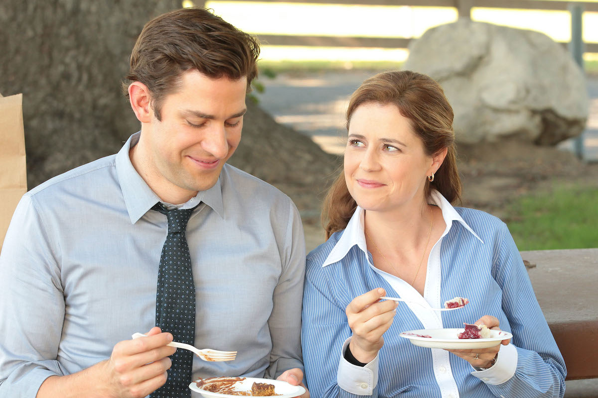 The Office Jenna Fischer and John Krasinski smile while eating pie as Jim and Pam.