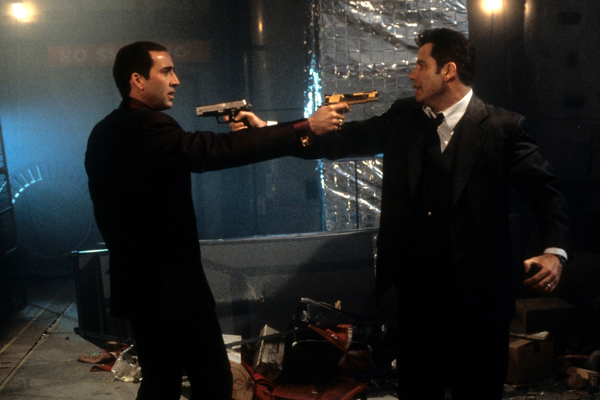 John Travolta and Nicolas Cage point guns at each other