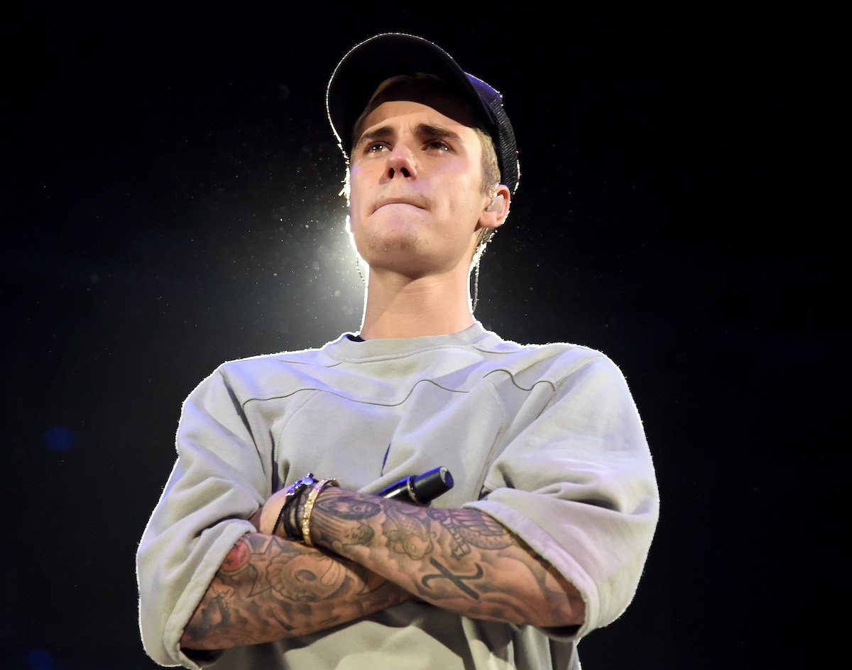 Justin Bieber stands with his arms crossed onstage during An Evening With Justin Bieber at Staples Center