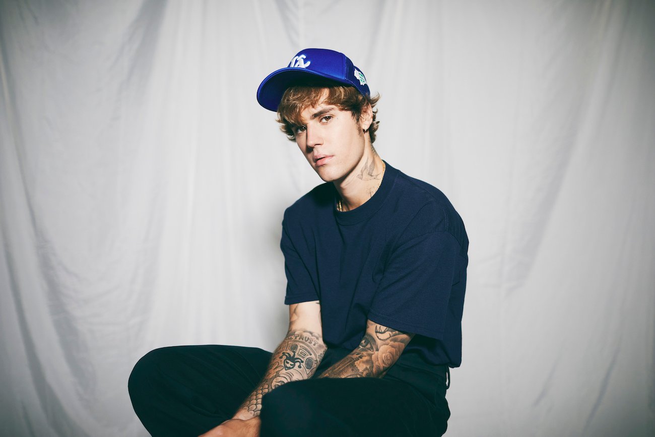 Justin Bieber poses wearing jeans, a t-shirt, and a baseball cap during a photo shoot in August 2020