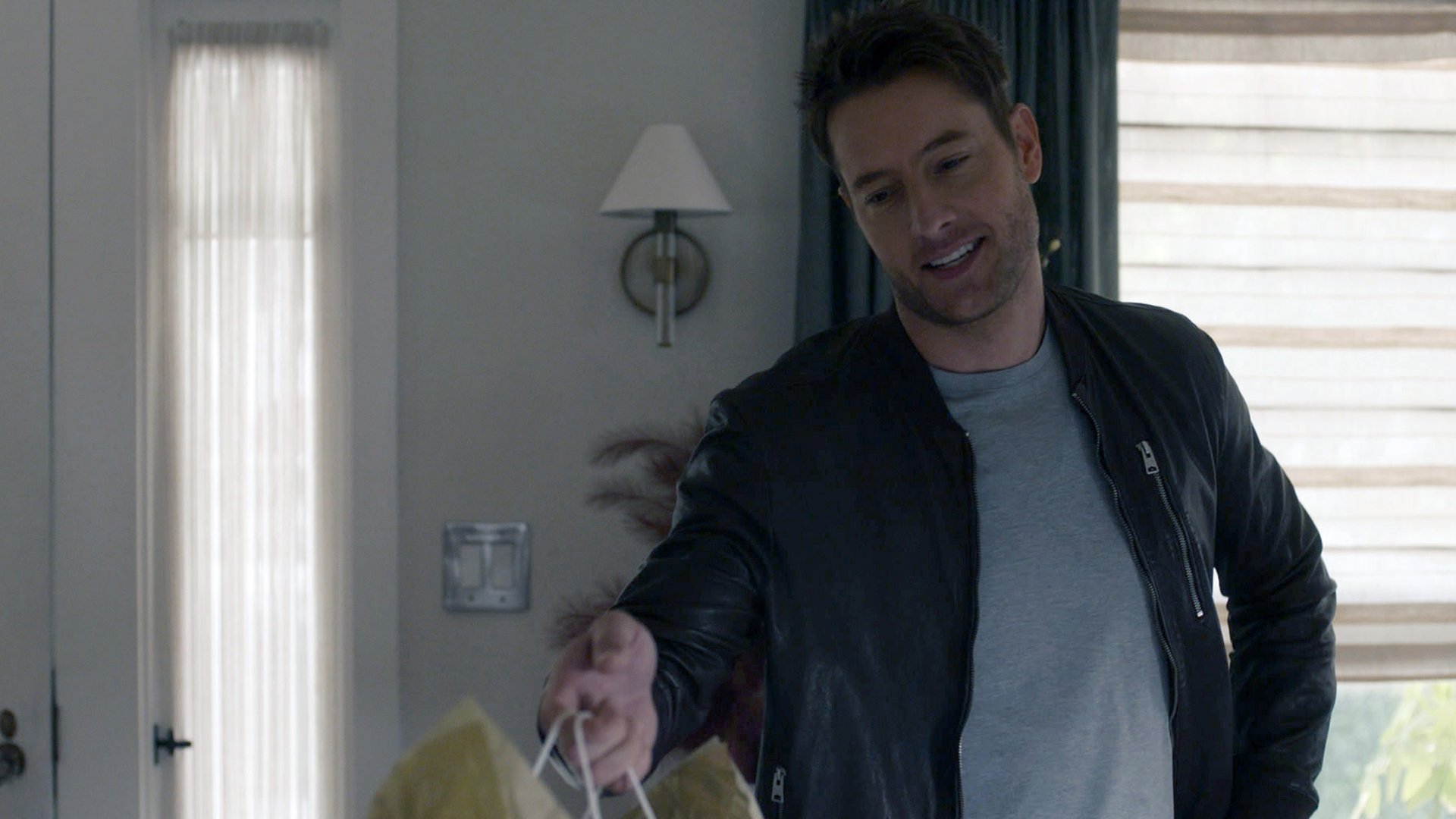 Justin Hartley as Kevin Pearson handing out a gift in ‘This Is Us’ Season 5 Episode 10