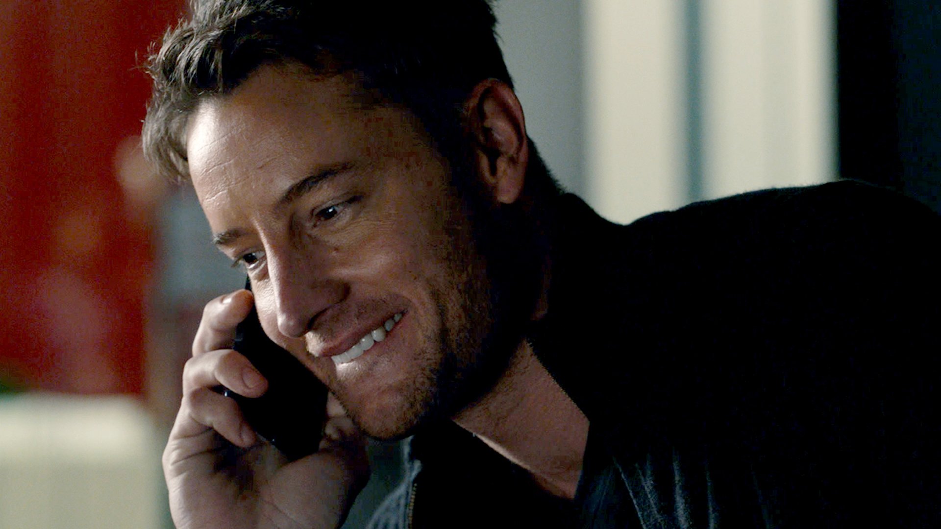 Justin Hartley as Kevin smiling on the phone on ‘This Is Us’ Season 5 Episode 8 