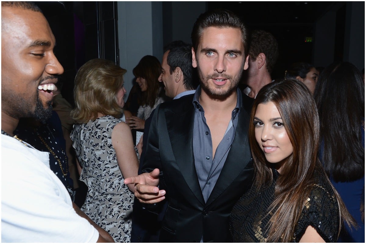 Kanye West, Scott Disick, and Kourtney Kardashian smiling at an event.