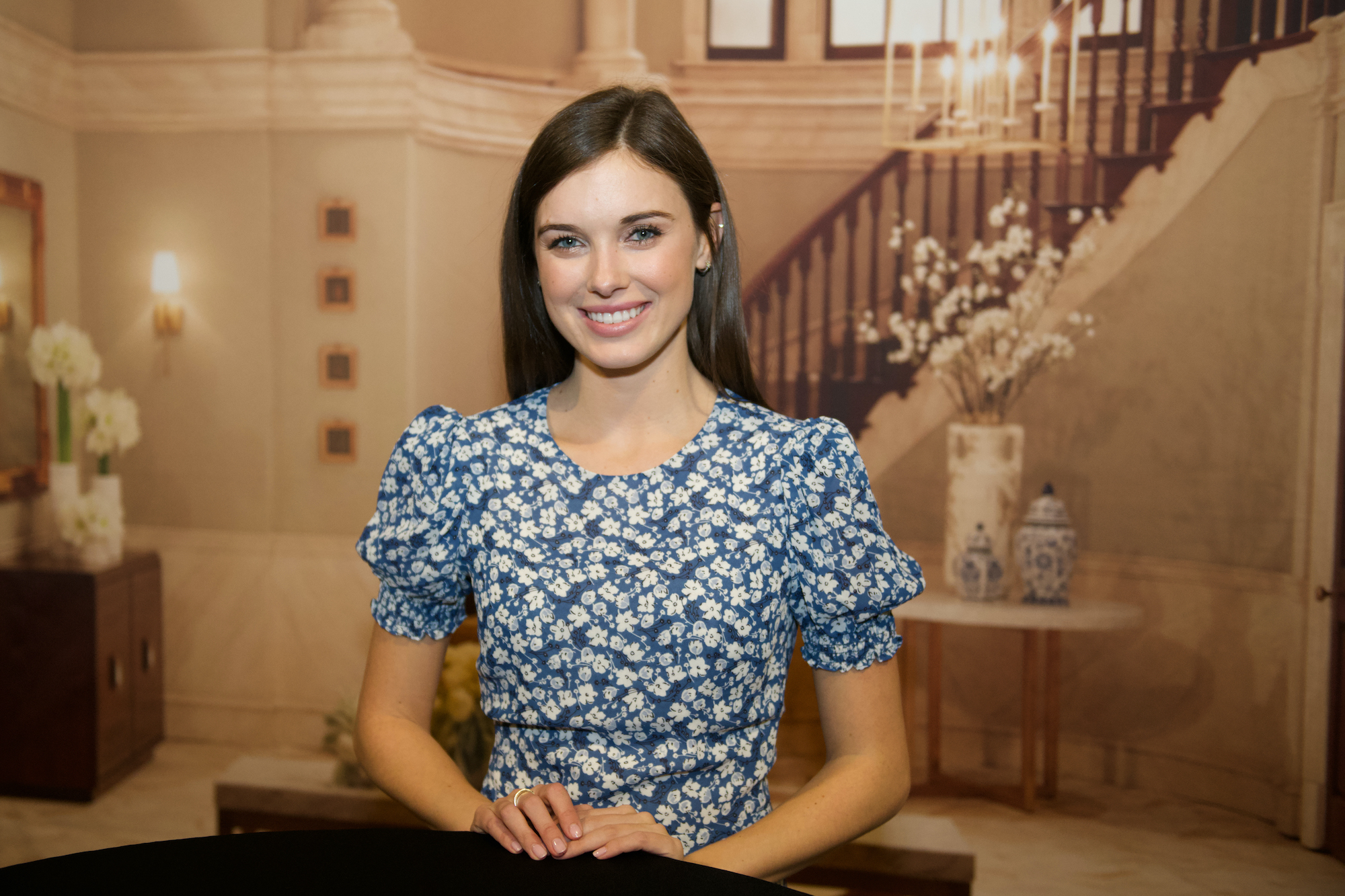 Katelyn MacMullen smiling in front of a staircase backdrop