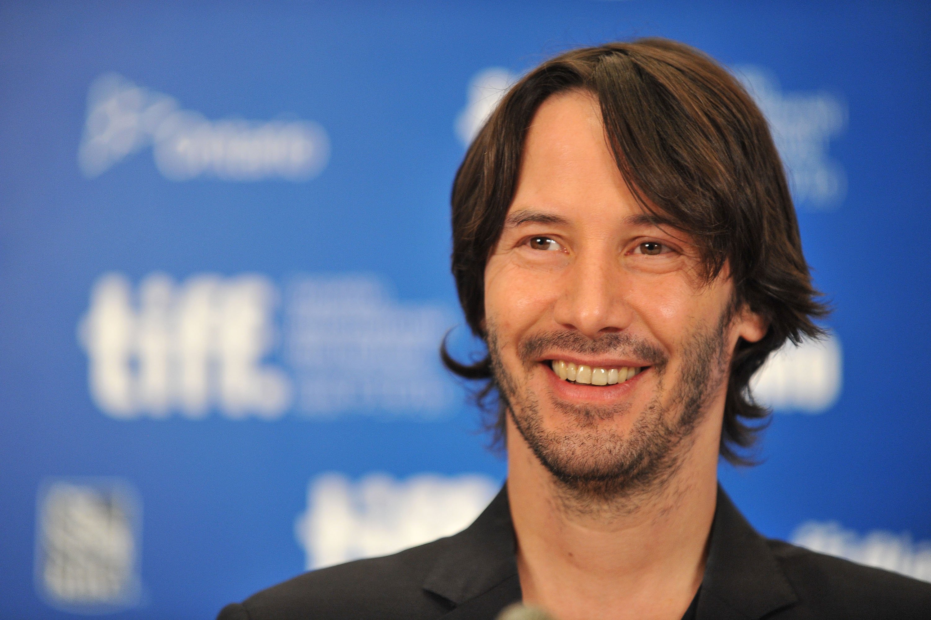 Keanu Reeves smiling at the Toronto Film Festival