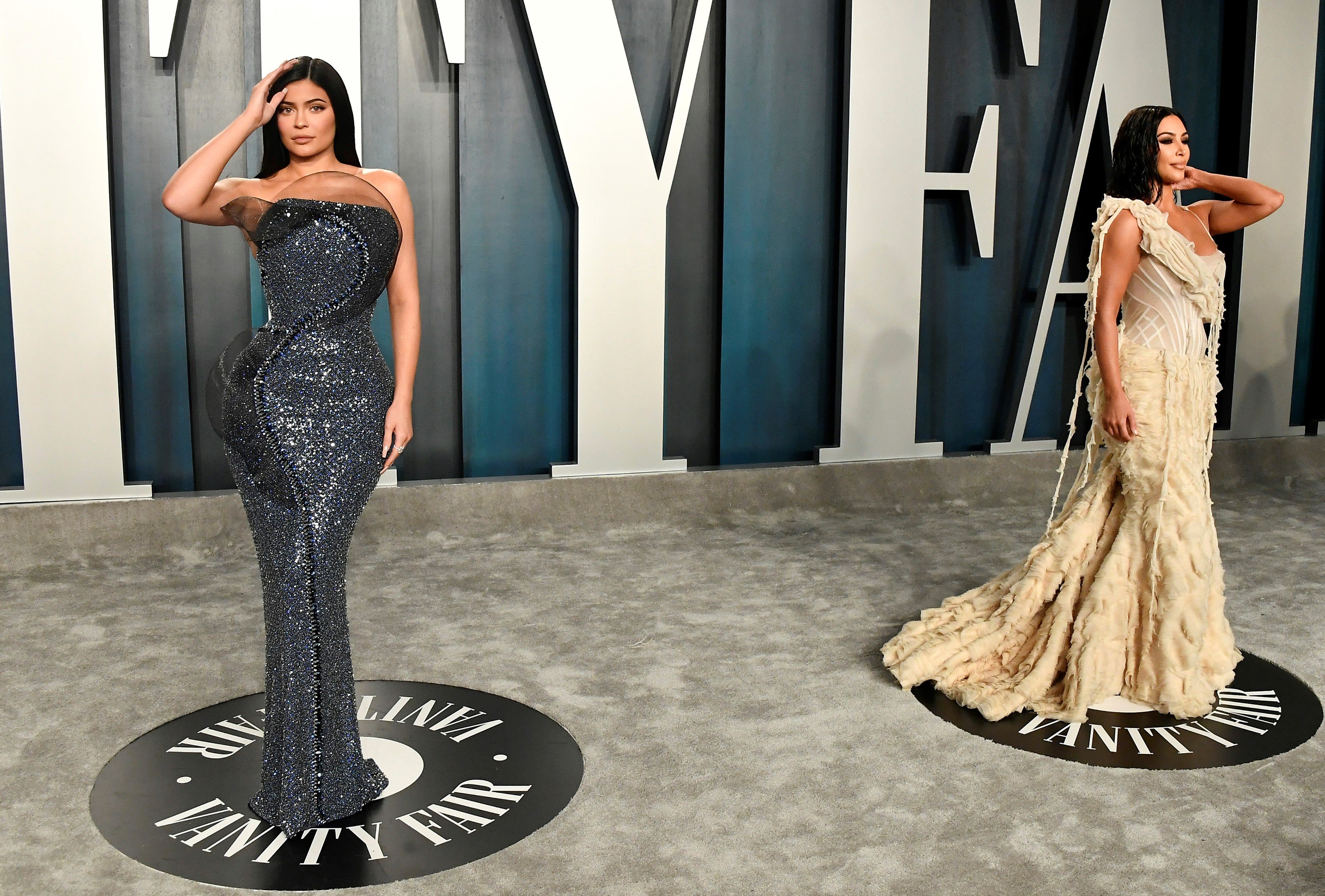 Kylie Jenner dons a sparkling gown and Kim Kardashian West rocks a cream-colored dress on the carpet at the 2020 Vanity Fair Oscar Party