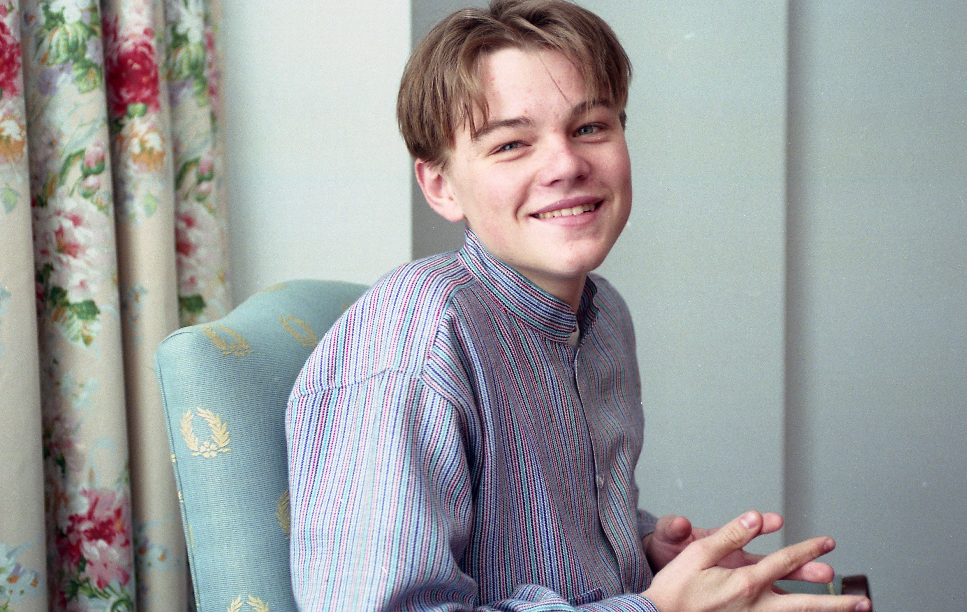 Leonardo DiCaprio sitting in a chair at age 17 