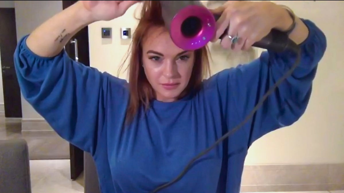 Actress Lindsay Lohan blow-dries her hair on 'Haircut Night in America,' hosted by Jerry O'Connell and Rebecca Romijn, on the CBS Television Network. Image is a screengrab.