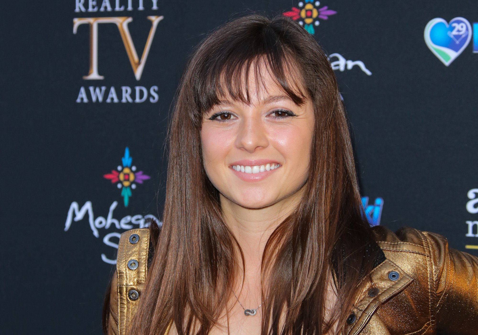 Mackenzie Rosman smiling in front of a black background