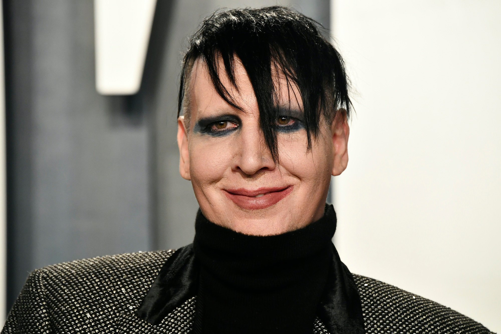 Marilyn Manson smiling in front of a blurred background