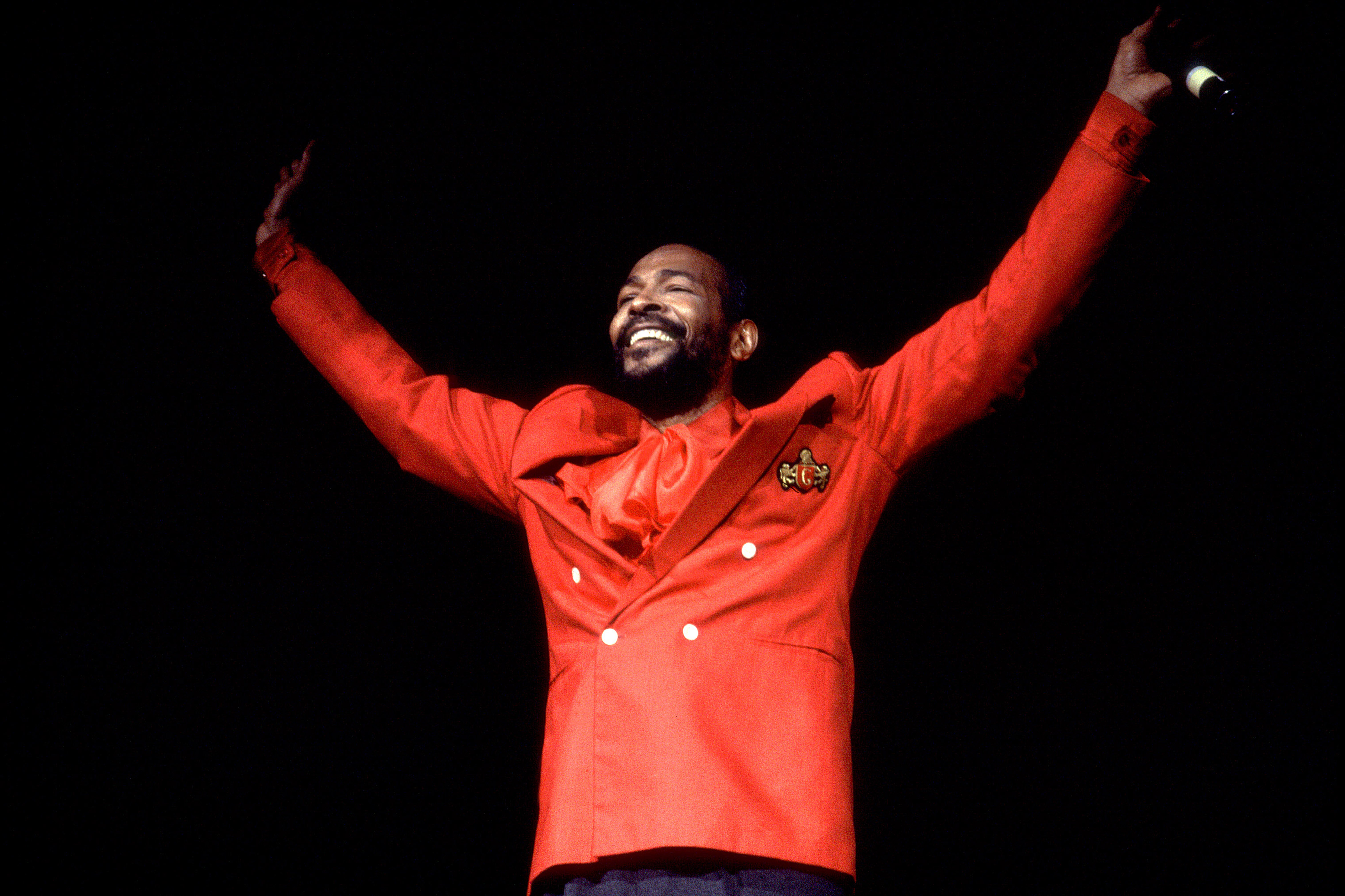 Marvin Gaye raising his hands onstage after a performance in 1983