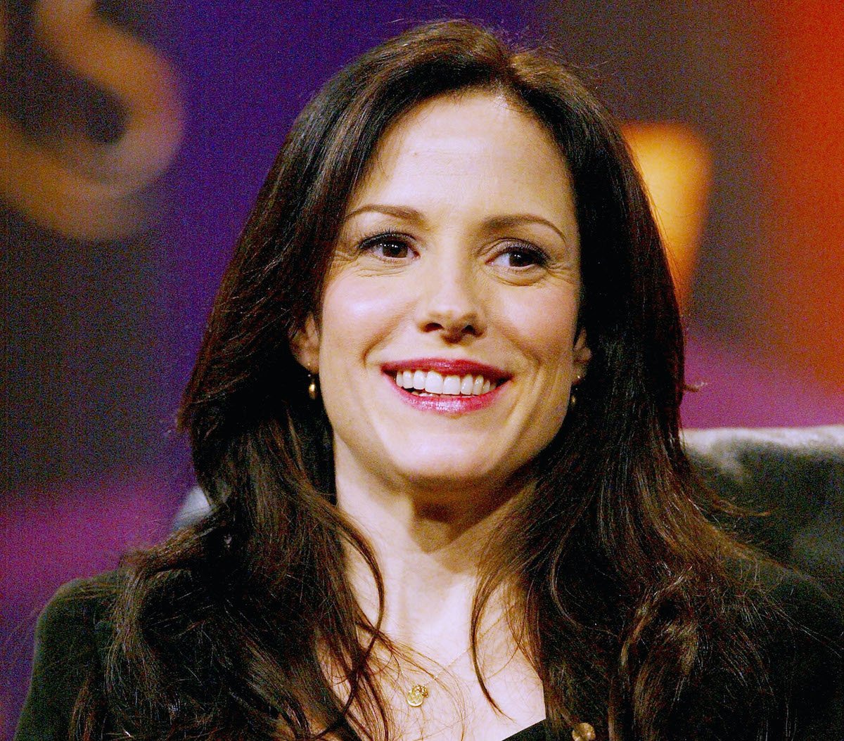 Mary-Louise Parker of 'Weeds' sitting in a chair in front of a purple and orange backdrop | Frederick M. Brown/Getty Images