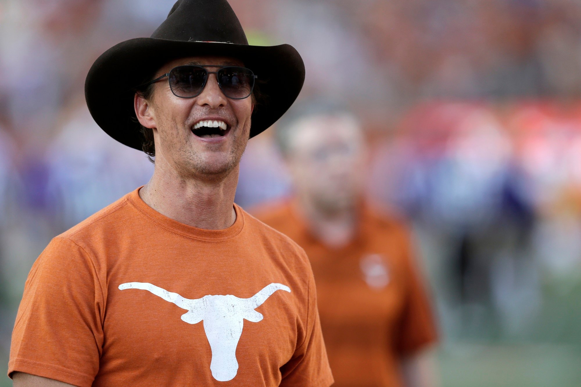 Matthew McConaughey wearing a Texas Longhorns shirt and cowboy hat