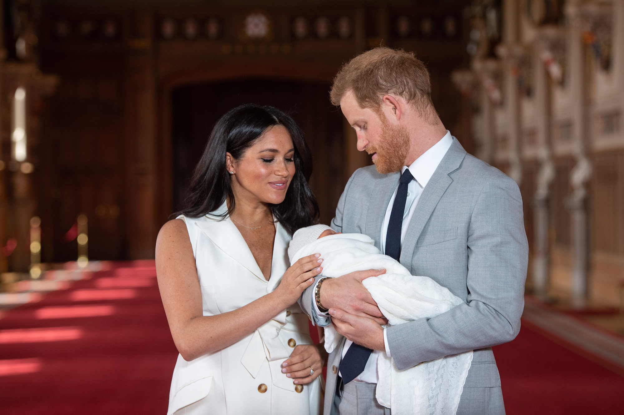 (L-R) Meghan Markle smiling and Prince Harry holding baby Archie