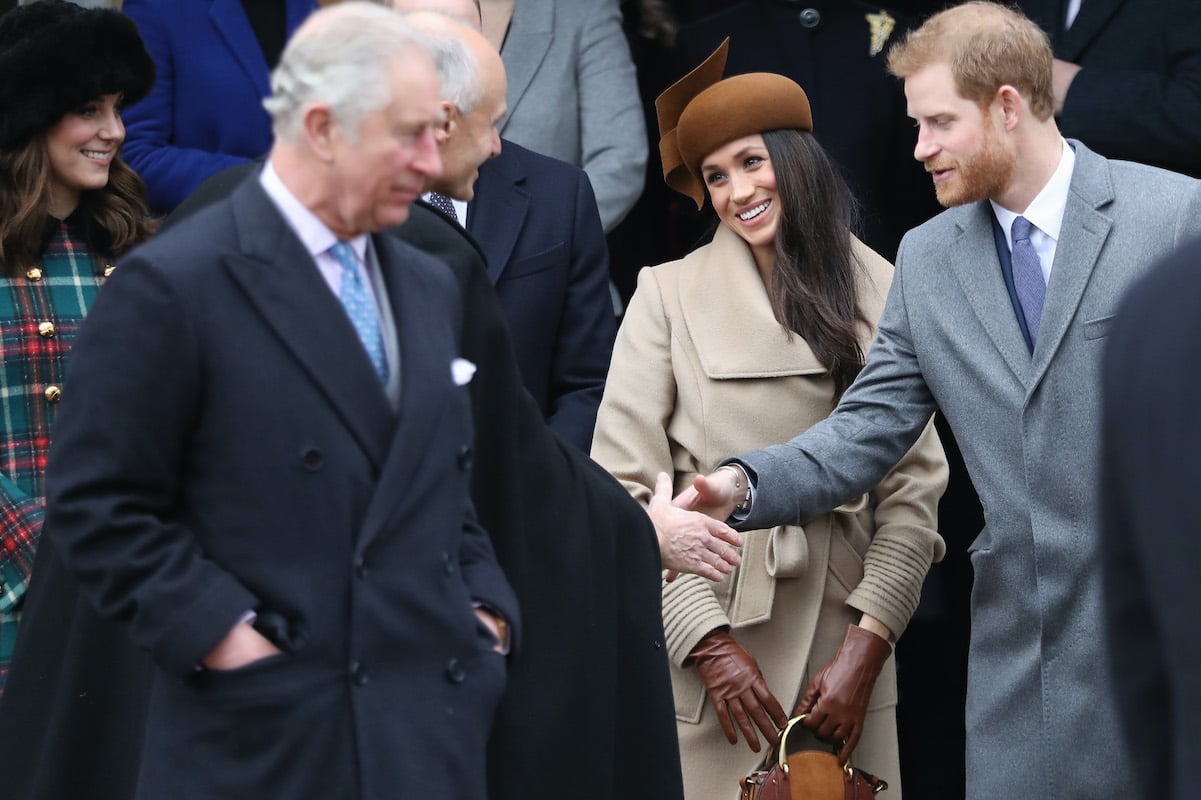 Prince Charles stands in front of Prince Harry and Meghan Markle at Christmas in 2017