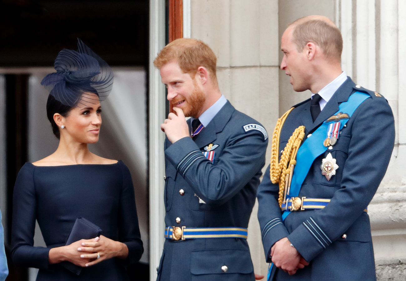 Meghan Markle, Prince Harry, and Prince William standing on a balcony together