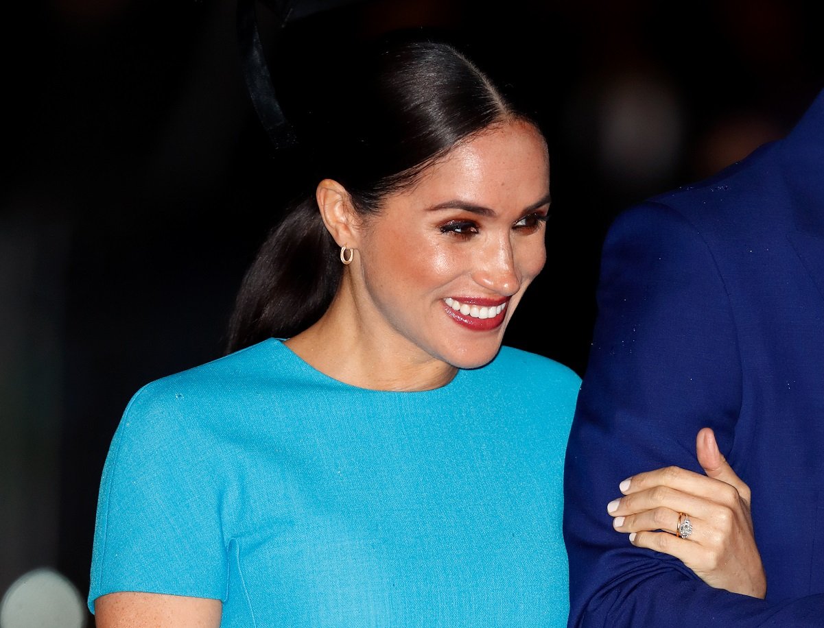 Meghan Markle smiles while attending one of her final royal engagements in London