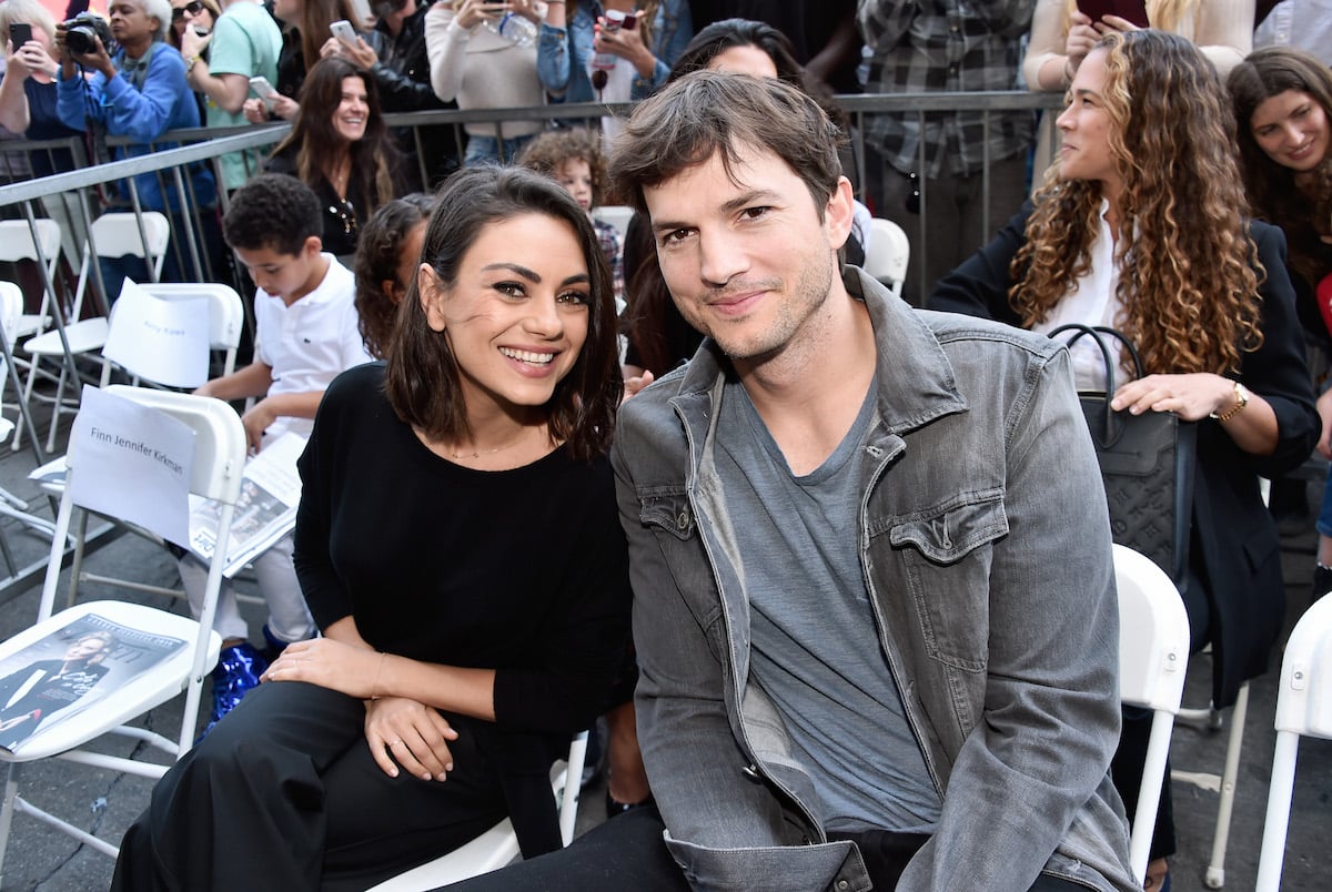 Mila Kunis and Ashton Kutcher smile as they next to each other at the Zoe Saldana Walk of Fame Star Ceremony